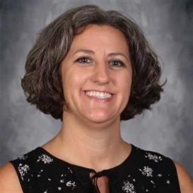 A person with short brown hair wearing a black dressDescription automatically generated with low confidence